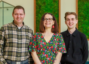 Three people standing in a row