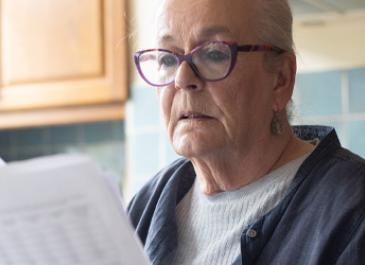 A woman examines some paperwork. 