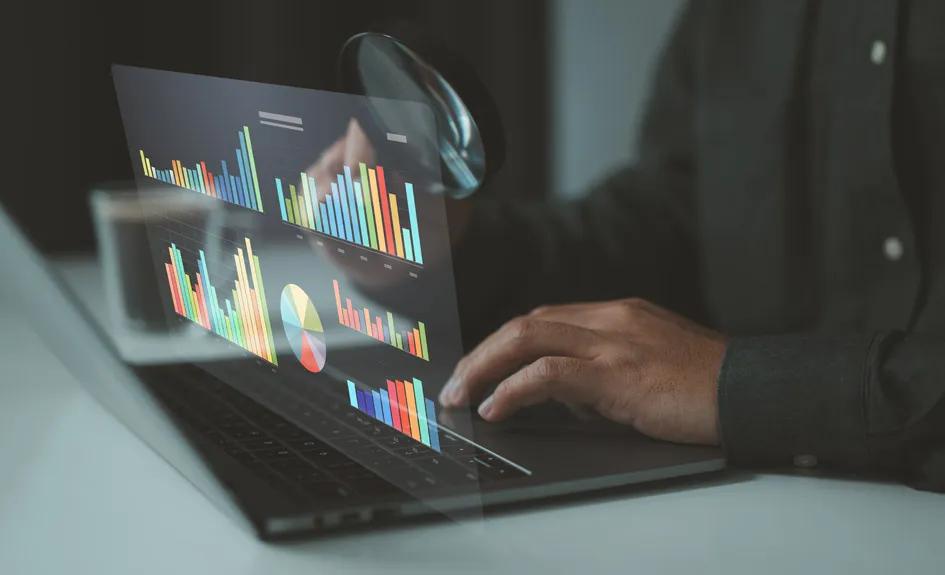 image of bar chart, icons and person at computer keyboard