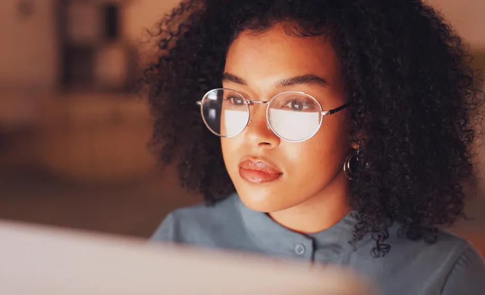 A woman looks at a computer screen.
