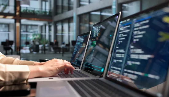 Image of hands at a computer screen and keyboard
