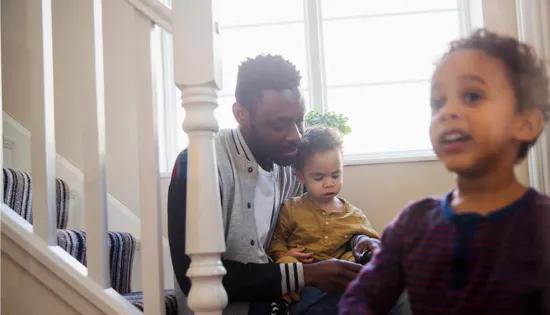 Man sitting on stairs with two young children