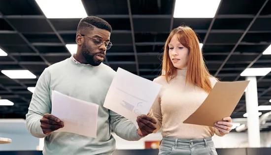 Two people discuss documents.