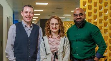 Three colleagues standing in hall