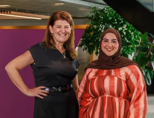 Two coworkers standing by spotlight