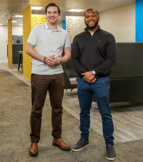 Two people standing in office