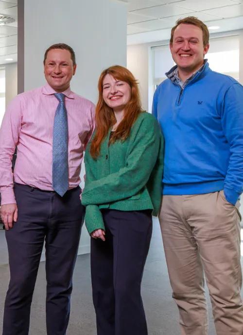 Three people standing in a row