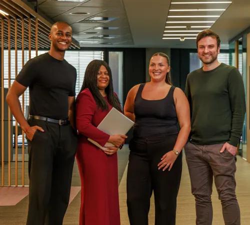 Four mixed colleagues standing in a row