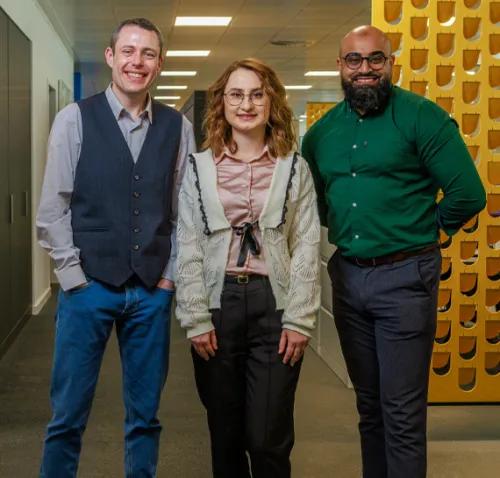 Three people standing in a row
